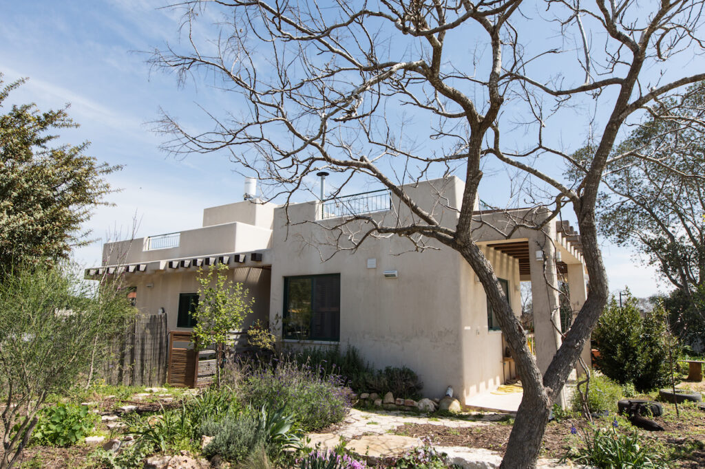 אדריכלות חוץ קורות עץ מצללה פינות עגולות עיצוב טבעי טיח טבעי