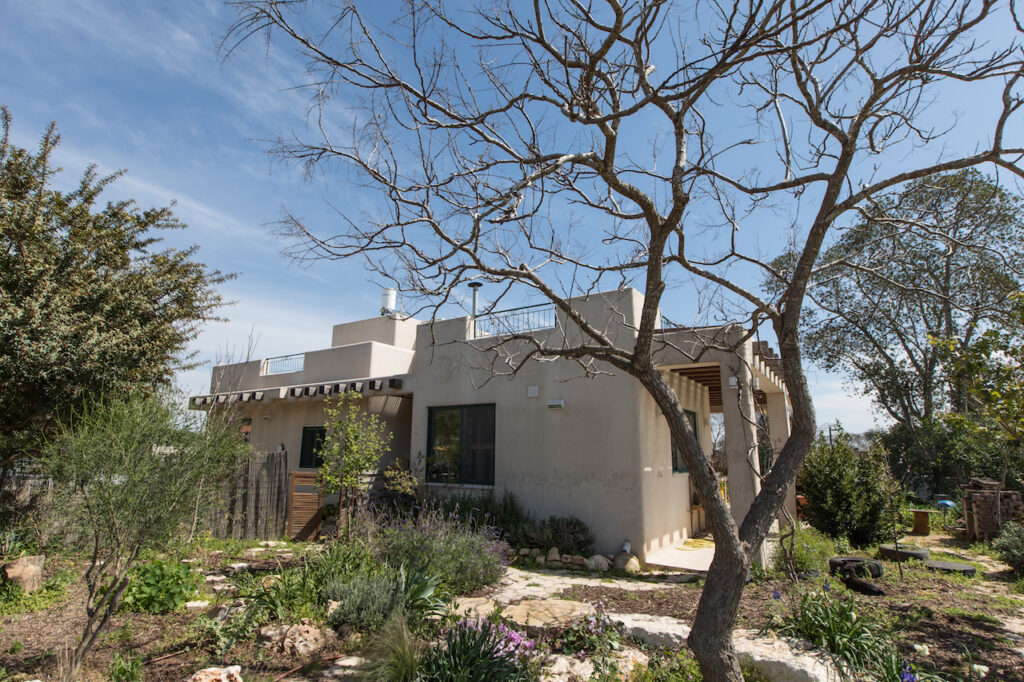 אדריכלות חוץ קורות עץ מצללה פינות עגולות עיצוב טבעי טיח טבעי